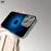 Black Apple Logo Blue Background Pattern Trendy Internet Celebrity High-Quality Texture Business Mirror Film Protection Cat Eye Electroplated Glass Design Suitable for iPhone 16 15 14 13 12 11 Exclusive Glass Phone Case, Anti