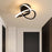 Modern Scandinavian LED ceiling light with minimalist black loop design illuminating a passageway