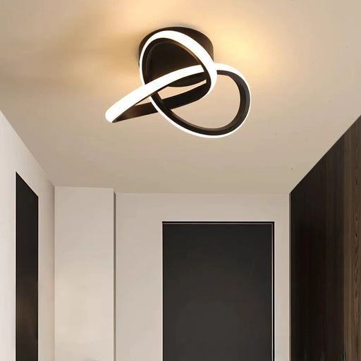 Modern Scandinavian LED ceiling light with minimalist black loop design illuminating a passageway