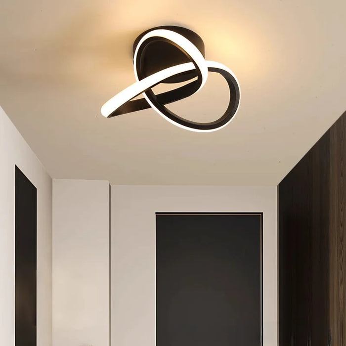 Modern Scandinavian LED ceiling light with minimalist black loop design illuminating a passageway